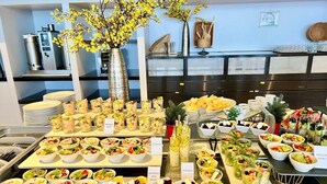 Buffet amb diferents plats, incloent ensalada de col, amanida de remolatxa i formatge feta, hummus i amanida mexicana.