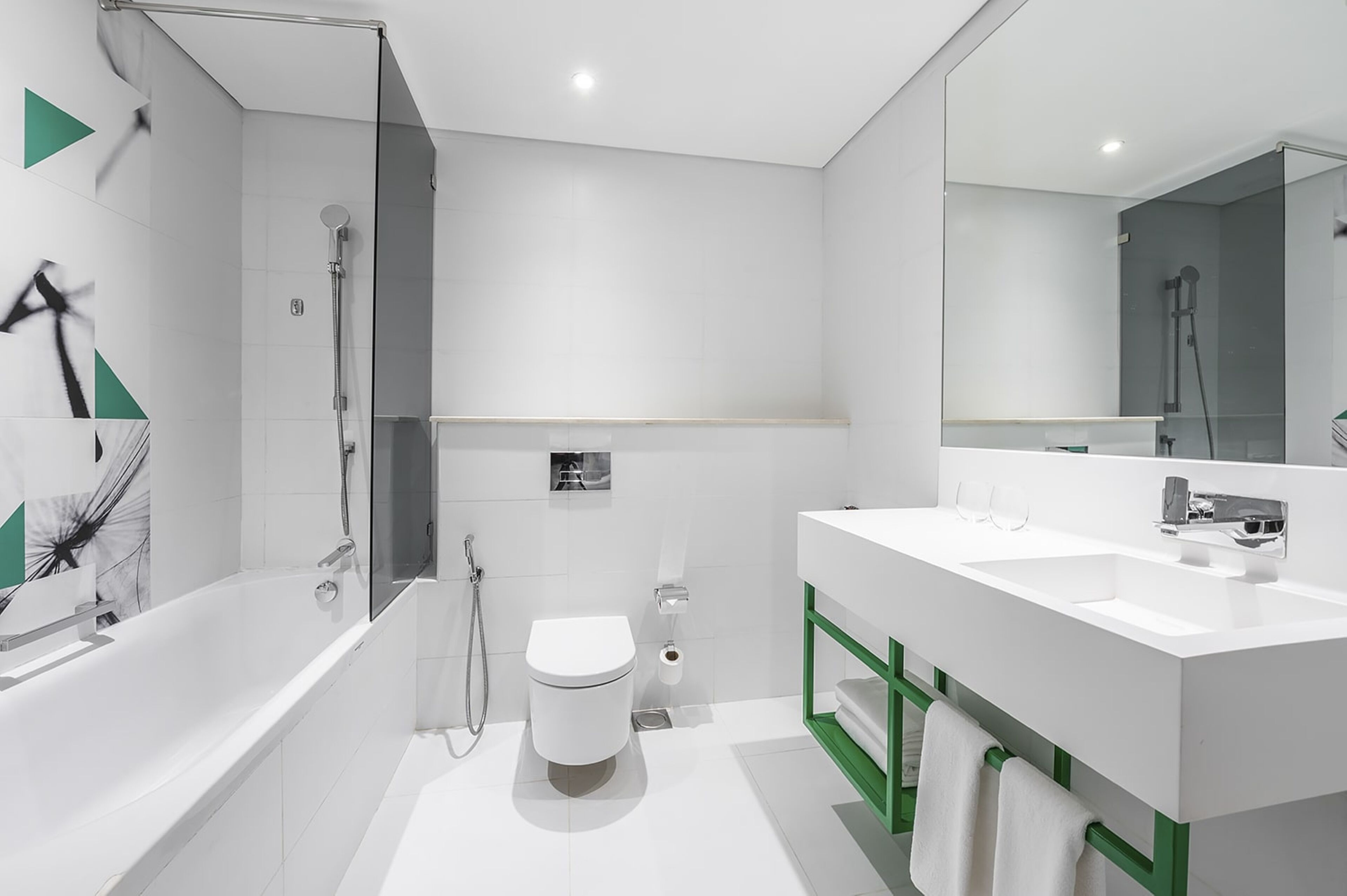 Ein modernes Badezimmer mit Badewanne, Toilette und einem großen Spiegel.