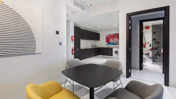 A modern kitchen with dark cabinets, a black countertop, and a large window.