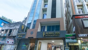 A hotel with a sign for 'Almas Inn Hotels & Resorts' and a nearby 'Lucky' store.