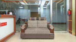 A reception area with a sofa, a reception desk, and a fire extinguisher.