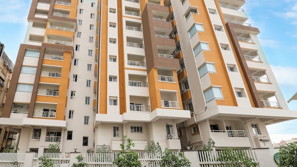 A multi-story residential building with balconies, a white and brown color scheme, and a gated entrance. - OYO 14184 Hotel Green Stone (Hyderabad)