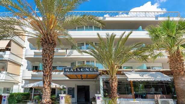 A hotel with a prominent sign, multiple balconies, and palm trees in the foreground. - Maison 66 Riviera Hotels (Alimos)