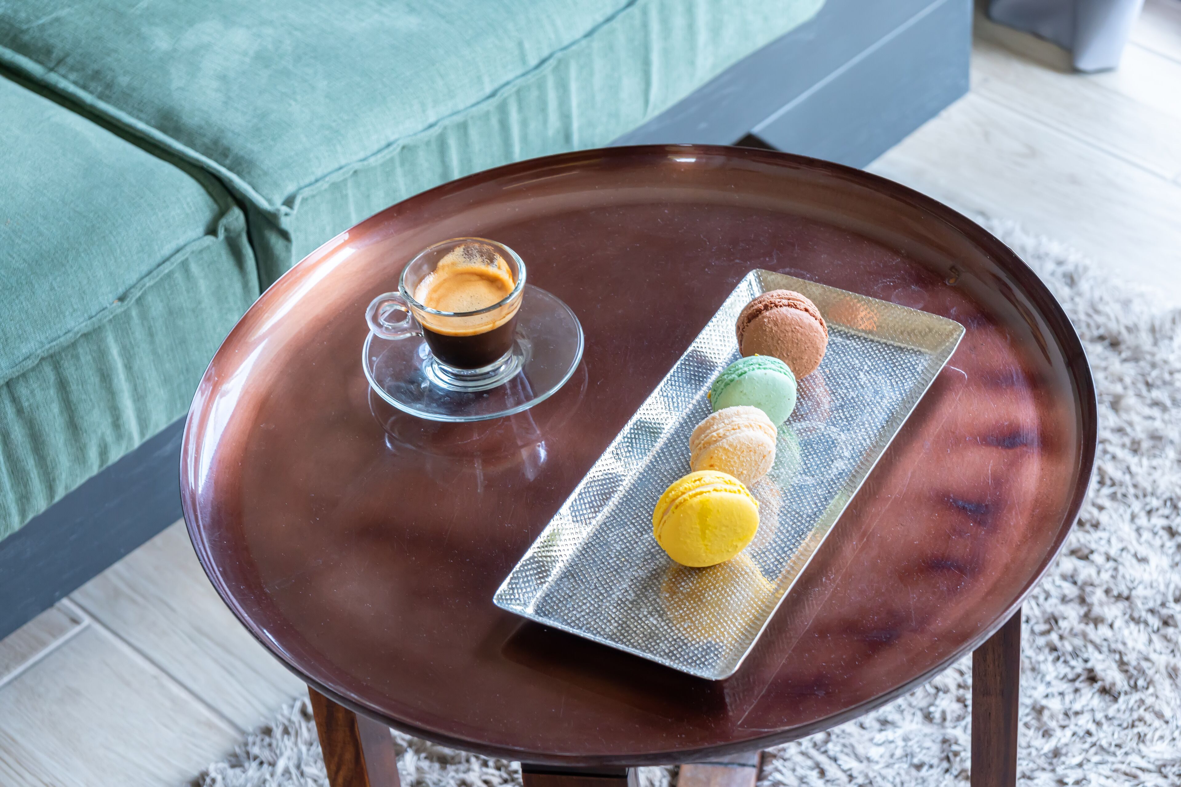 A table with a cup of coffee and macarons.