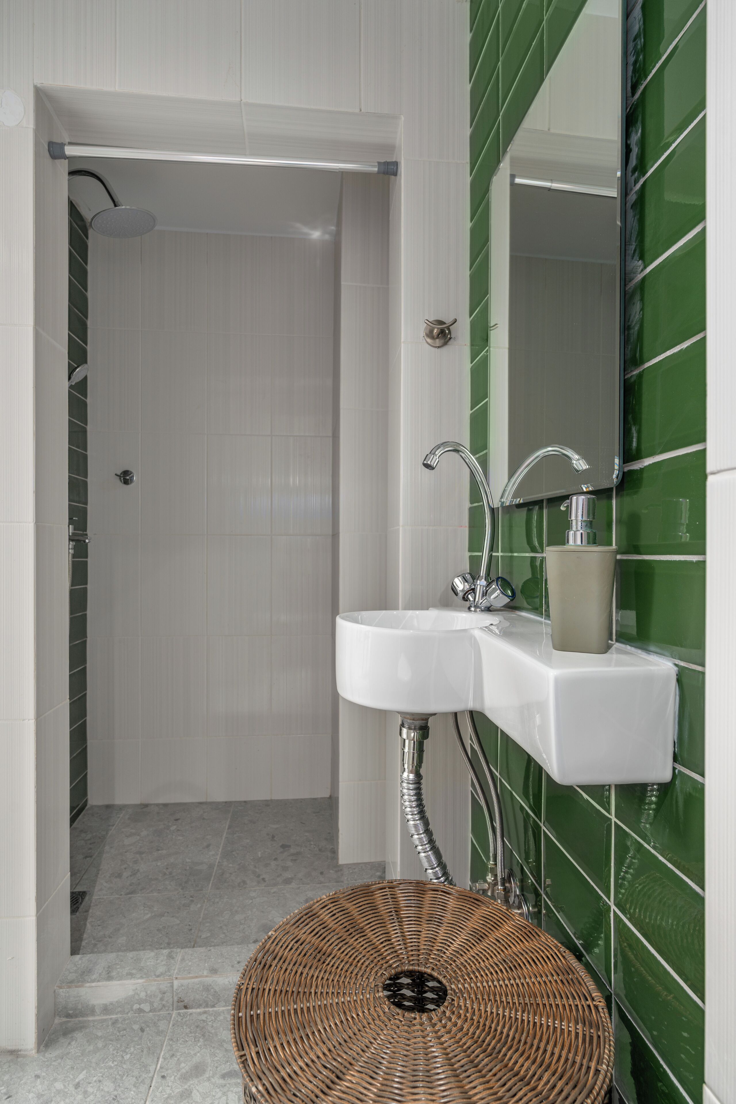 Un baño con ducha, lavamanos y espejo.