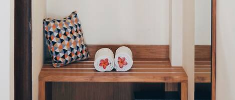 Un banco de madera pequeño con un cojín y dos toallas con diseños florales.