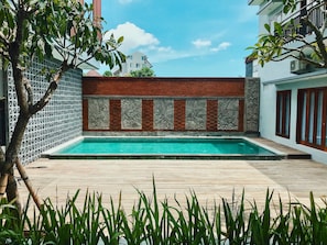 Una piscina al aire libre, sillones reclinables de piscina