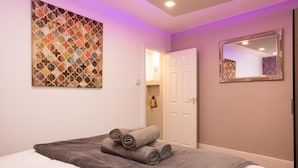 A hotel room with a bed, a large abstract painting, a door, and a mirror. - Landmark Apartments Harrogate (Harrogate)
