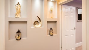 A hallway with decorative wall shelves, a statue, and two lanterns. - Landmark Apartments Harrogate (Harrogate)