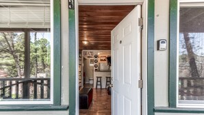 A wooden interior with a kitchen area, a dining table, and a bar.
