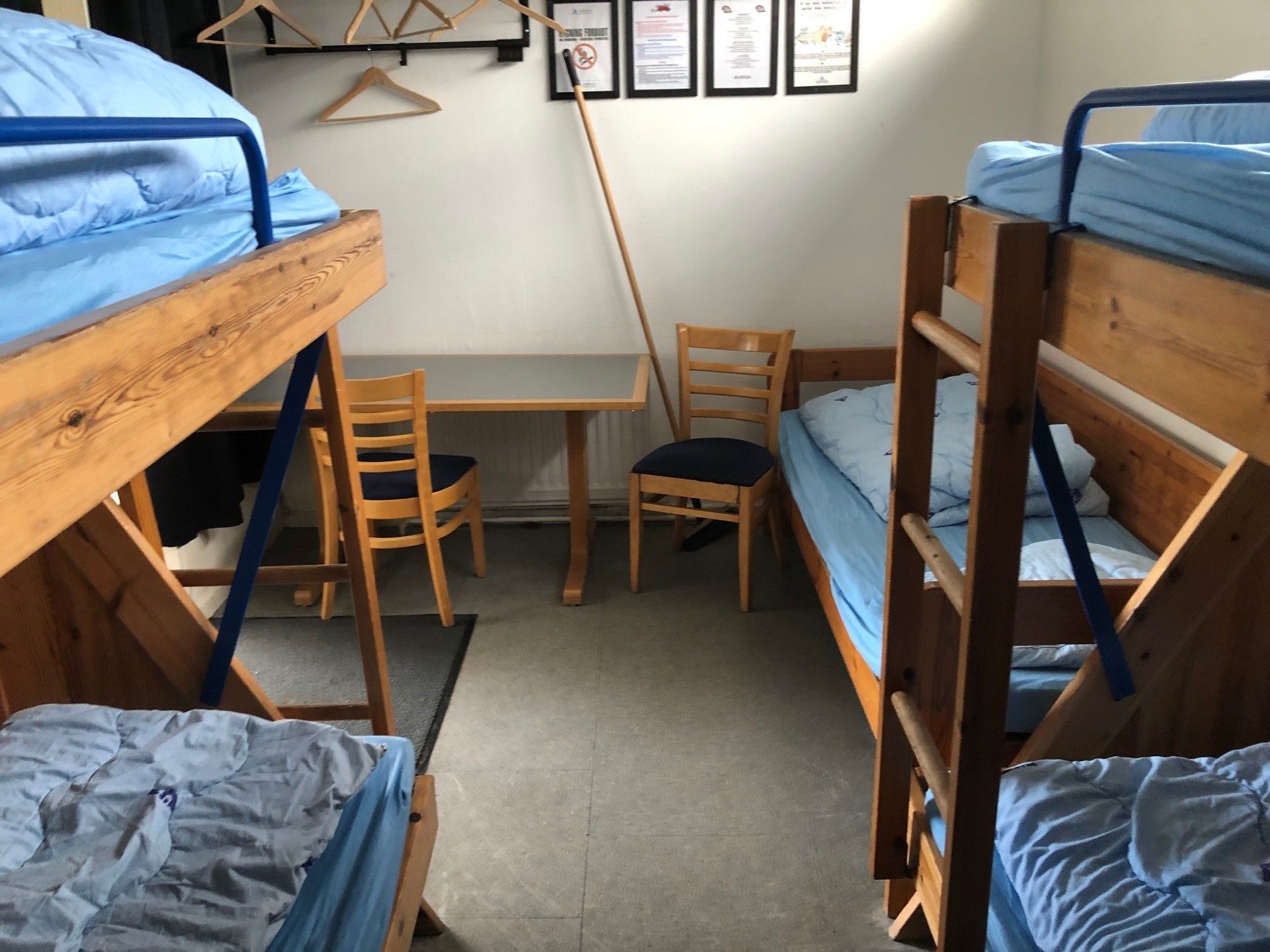 Una camera del dormitorio con letti a castello, una scrivania, una sedia e un termosifone.