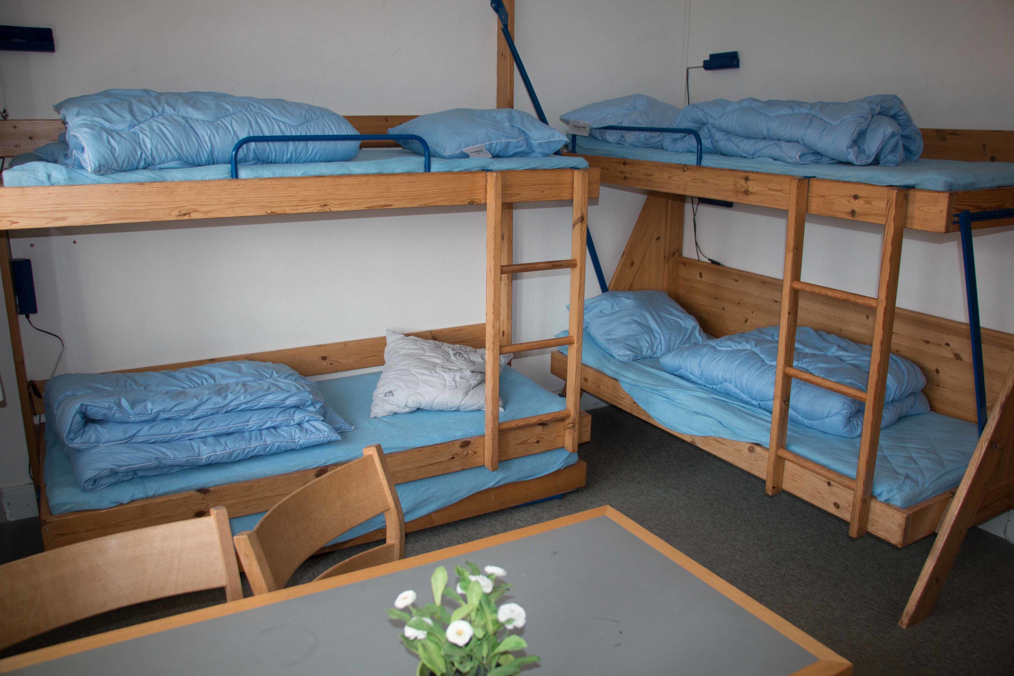 Un dormitorio con literas, una mesa y una silla.