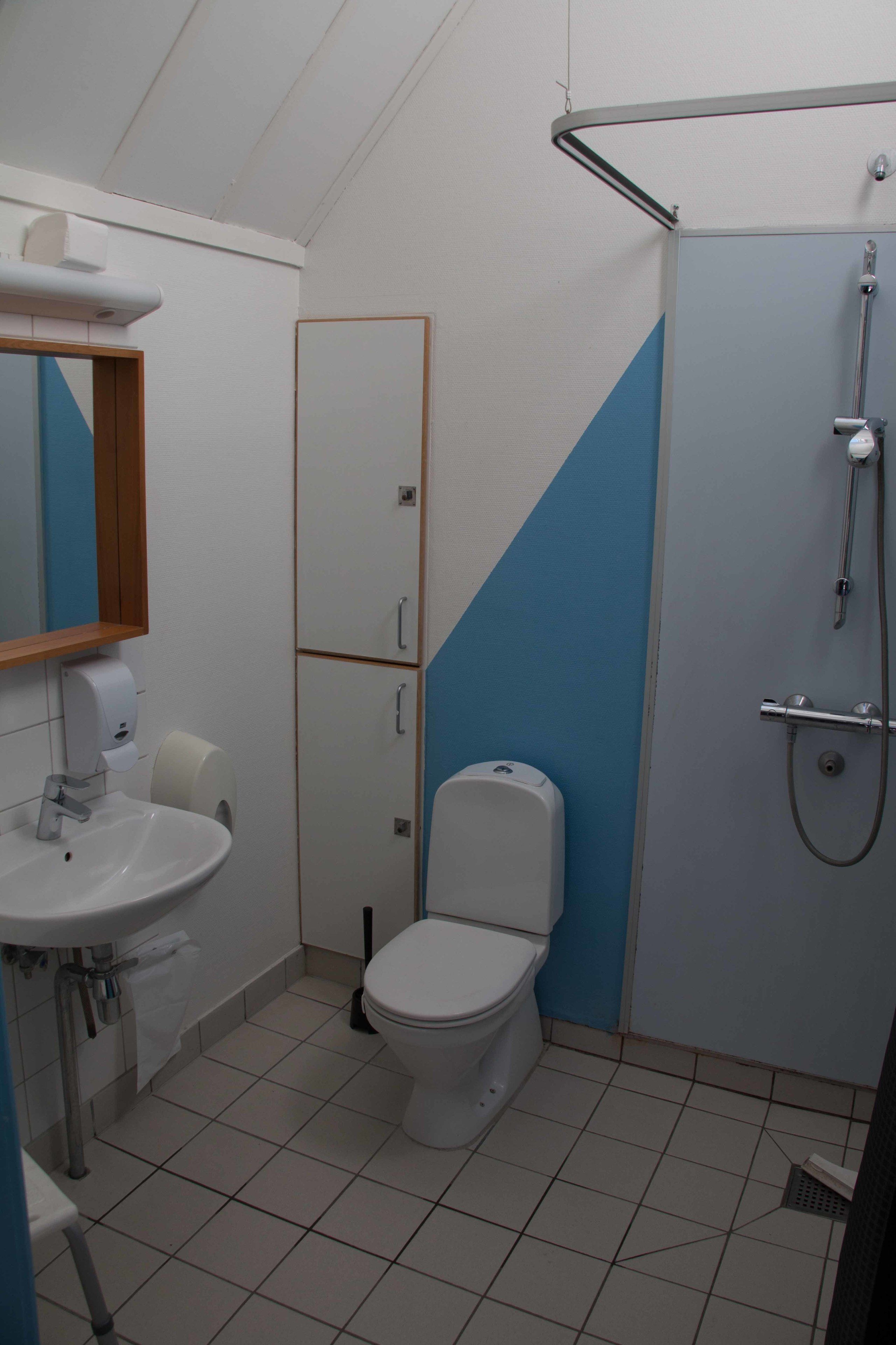 A bathroom with a sink, toilet, and shower.