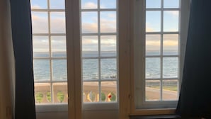 A room with a large window overlooking a beach and the sea. - Danhostel Helsingør Vandrerhjem (Helsingor)