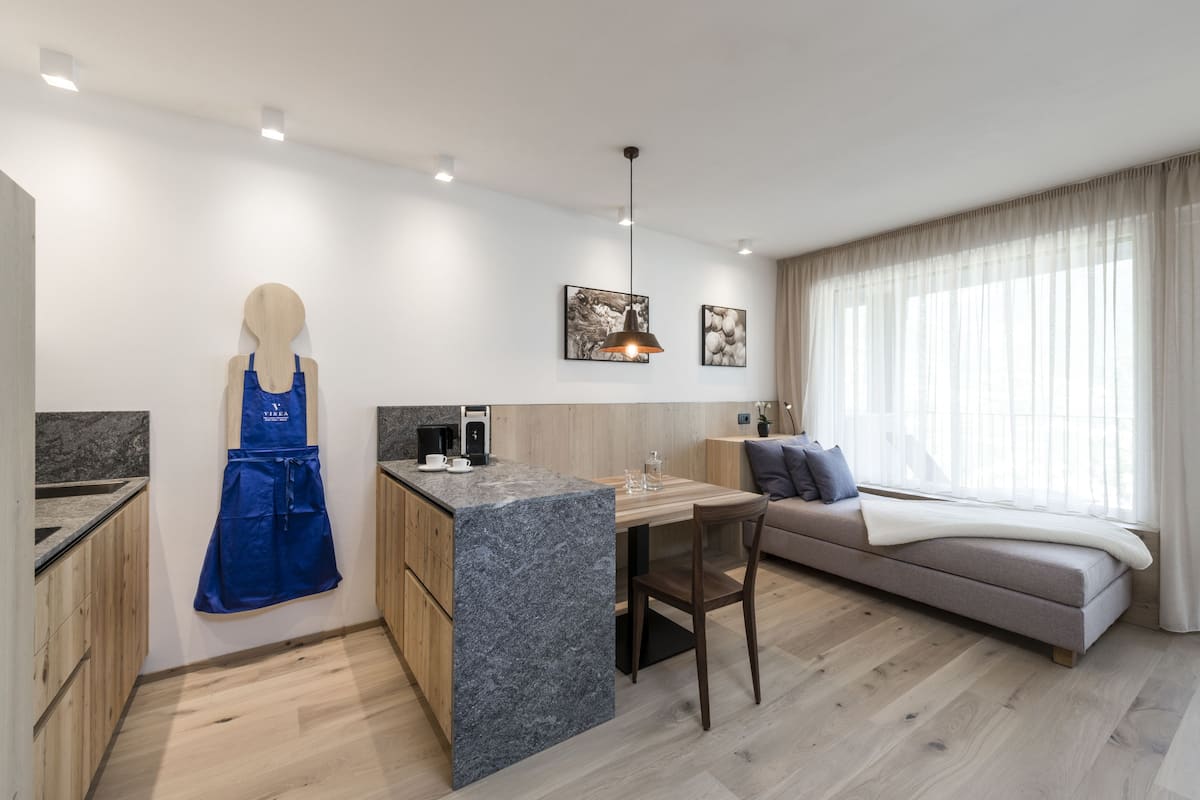 Une cuisine moderne avec un îlot en marbre, des armoires en bois et un tablier bleu accroché au mur.