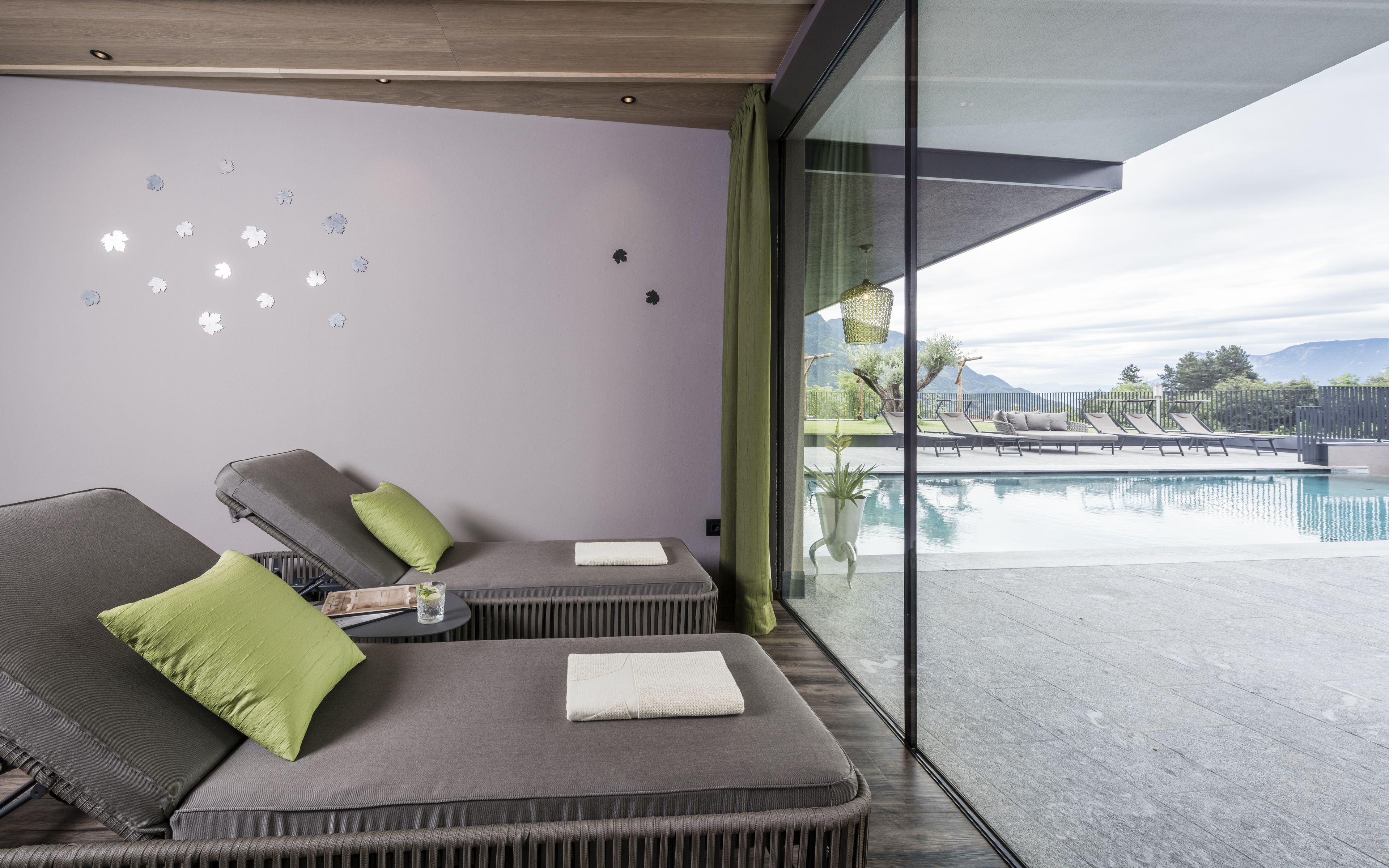 Habitación moderna con vista a la piscina, que incluye dos sillones, una mesita y un adorno en la pared.