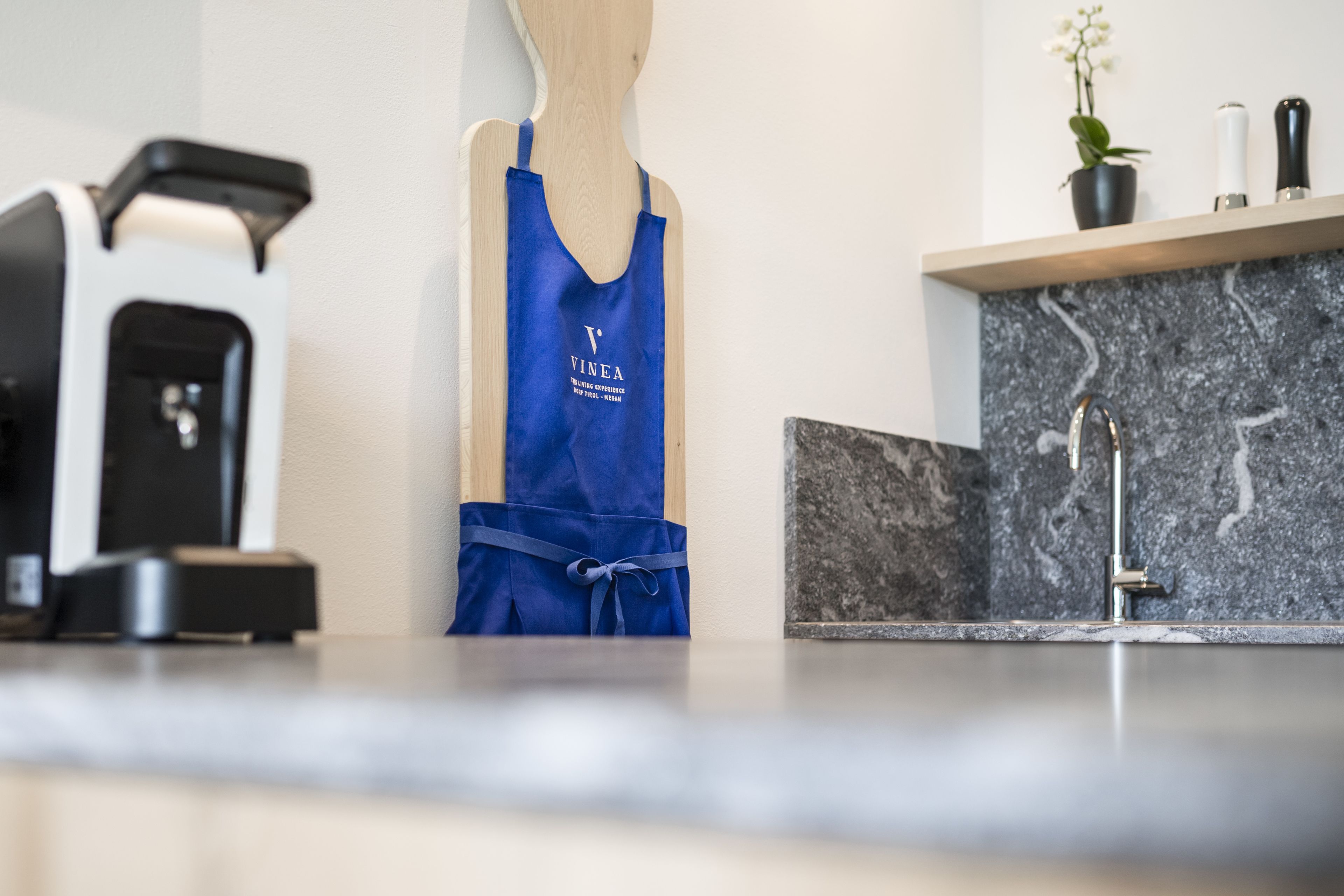 Une cuisine moderne dotée d’un plan de travail en marbre, d’un évier et d’une machine à café.