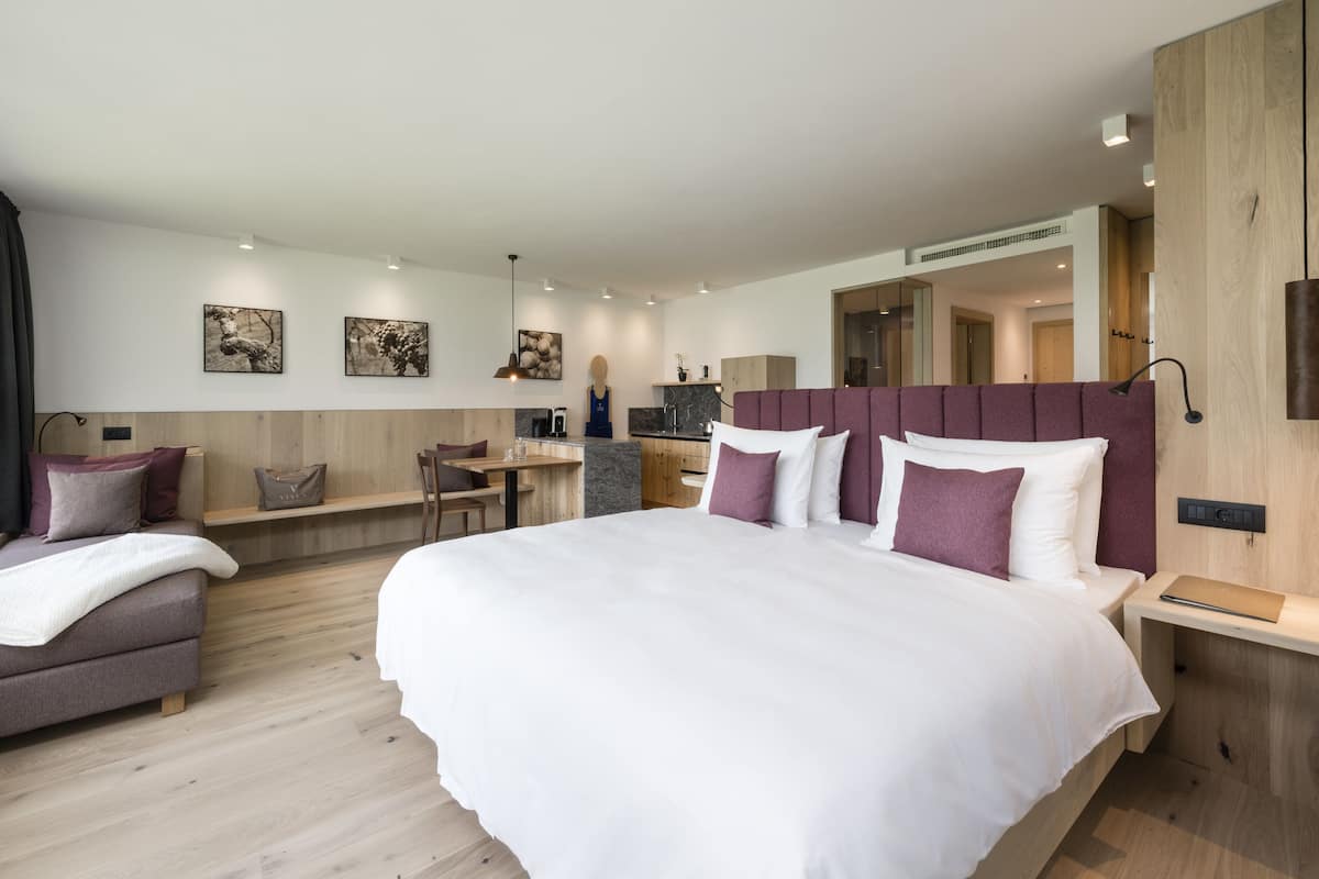 Une chambre d’hôtel moderne dotée d’un grand lit, d’un bureau et d’un coin salon.