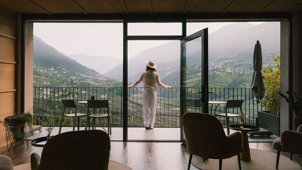 A spacious balcony with a view of a valley and mountains. - Vinea - Suites & Apartments (Tirolo)
