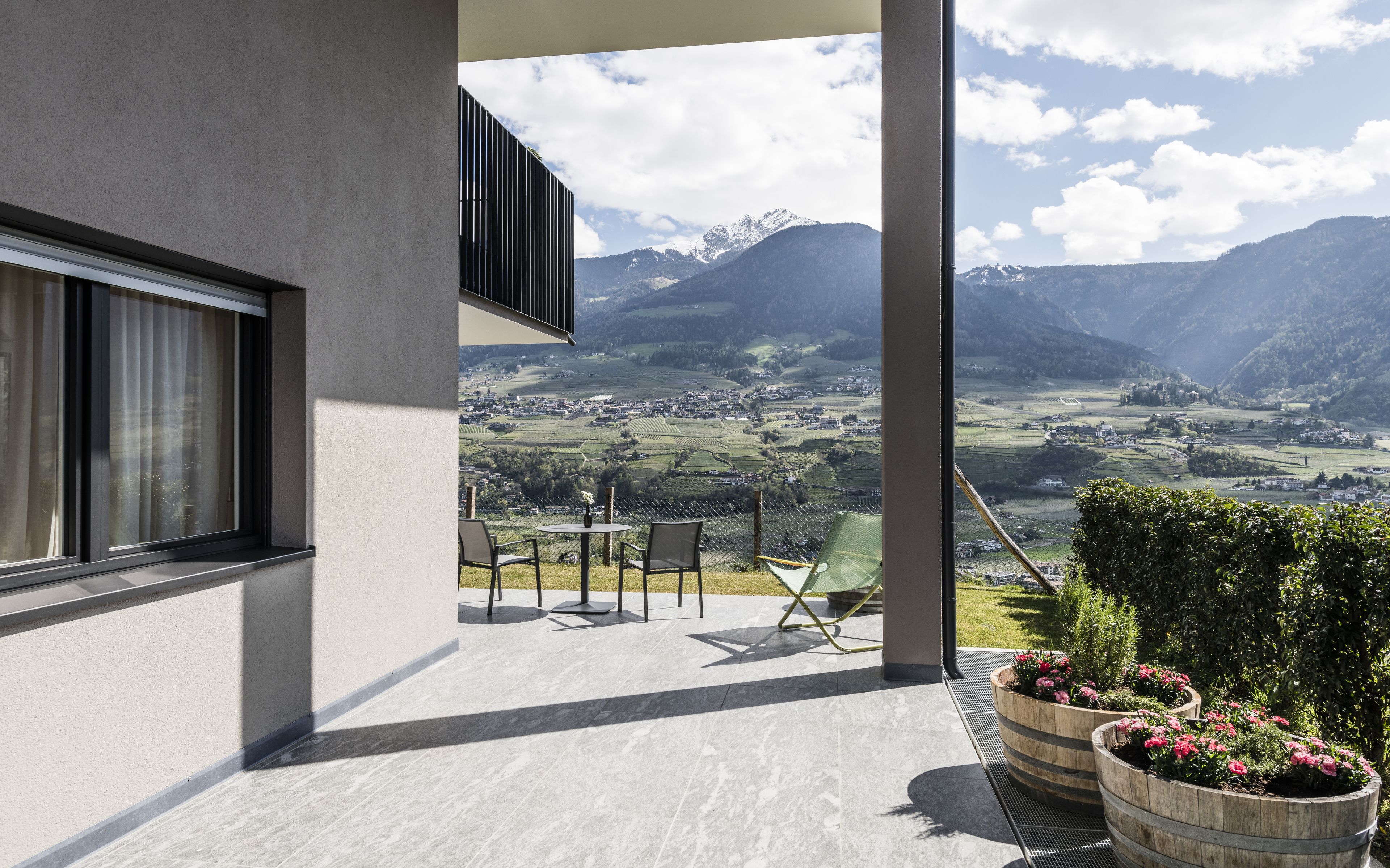 A balcony with a view of a valley and mountains.