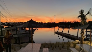 A waterfront restaurant with outdoor seating and a view of the sunset over the water. - C5, Flagler location in downtown, close to beaches, private patio, free parking! (St. Augustine)