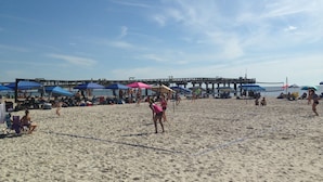 A beach with umbrellas and people. - C5, Flagler location in downtown, close to beaches, private patio, free parking! (St. Augustine)
