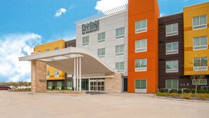 A multi-story hotel with a modern design, featuring a covered entrance and a variety of room colors. - Fairfield Inn & Suites by Marriott LaPlace (LaPlace)