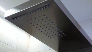 Una ducha moderna con un diseño metálico elegante y un panel perforado para el flujo de agua.