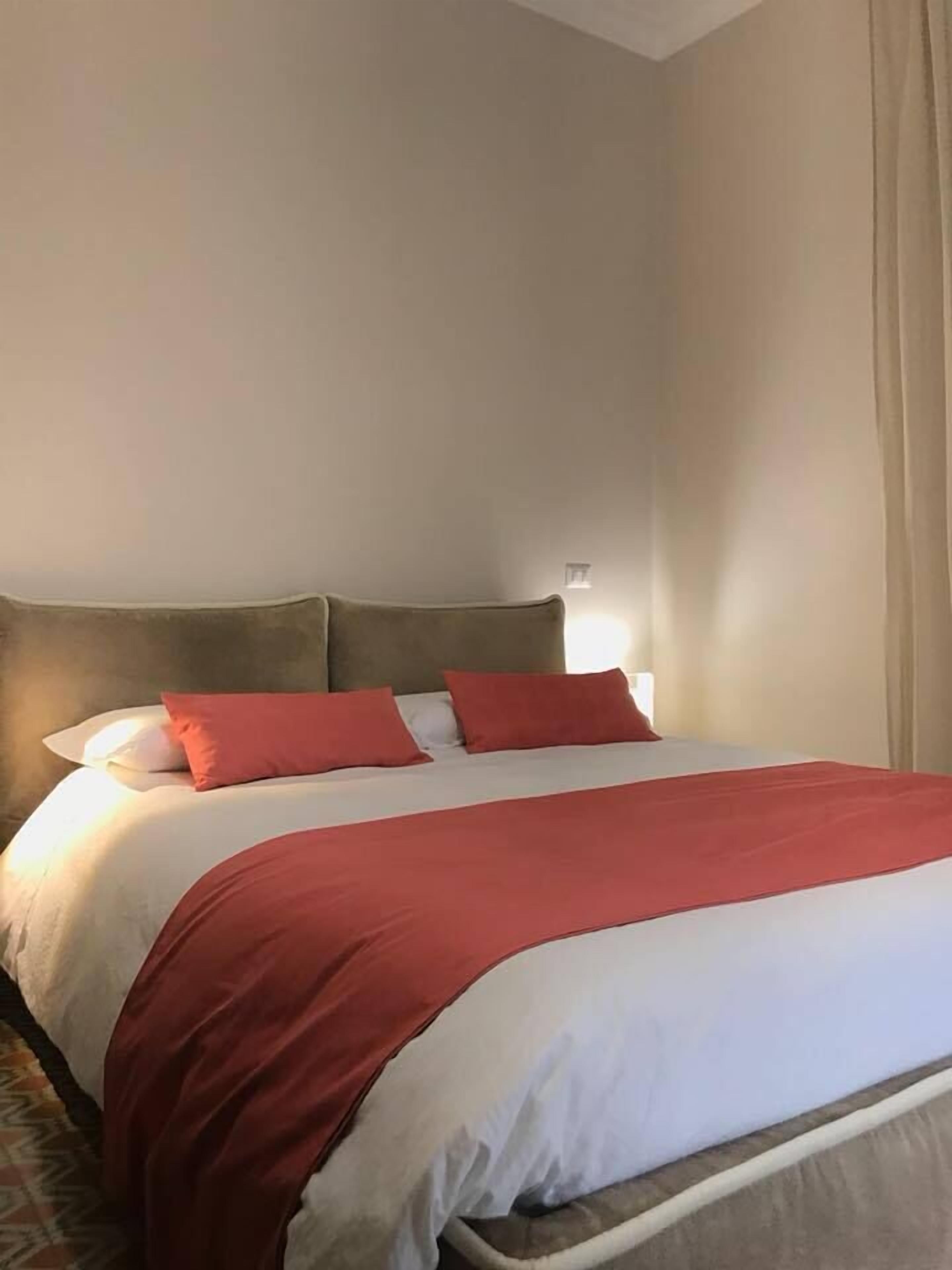A hotel room with a bed, a headboard, and a nightstand.
