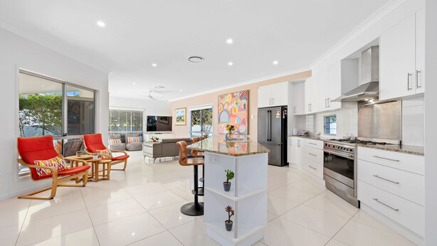A modern kitchen with white cabinets, stainless steel appliances, and a central island. - Splash House at Kingscliff - Pet Friendly with Pool (KINGSCLIFF)