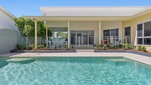 A modern house with a swimming pool, large windows, and a covered patio area. - Splash House at Kingscliff - Pet Friendly with Pool (KINGSCLIFF)