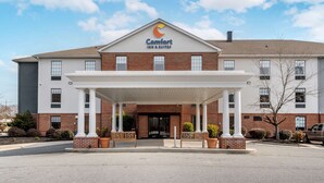 Een Comfort Inn & Suites hotel met een bakstenen gevel, een overdekte ingang en een heldere lucht.