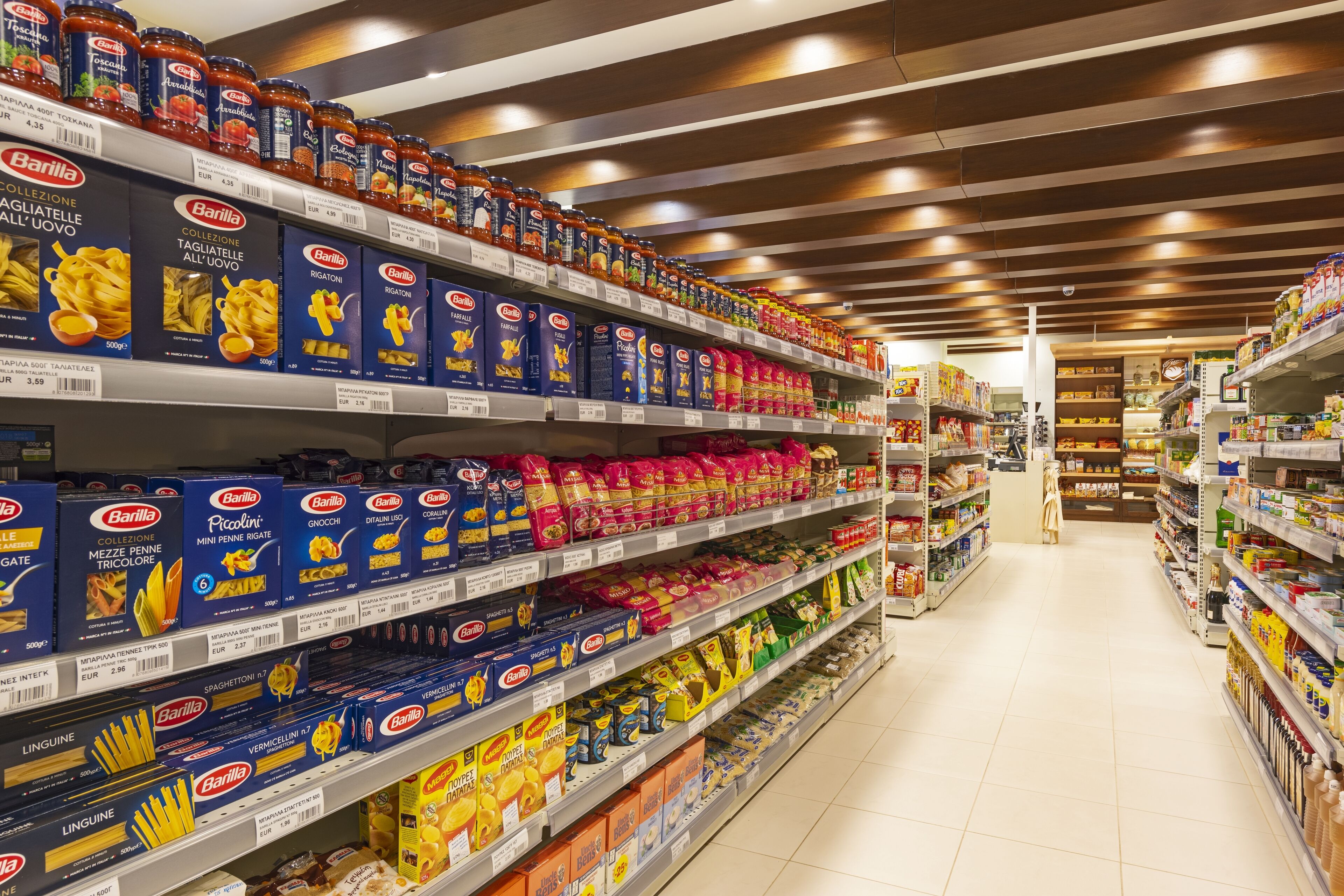 Een schap in een supermarkt met pasta en andere levensmiddelen.