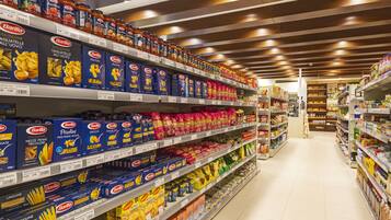 Een schap in een supermarkt met pasta en andere levensmiddelen.
