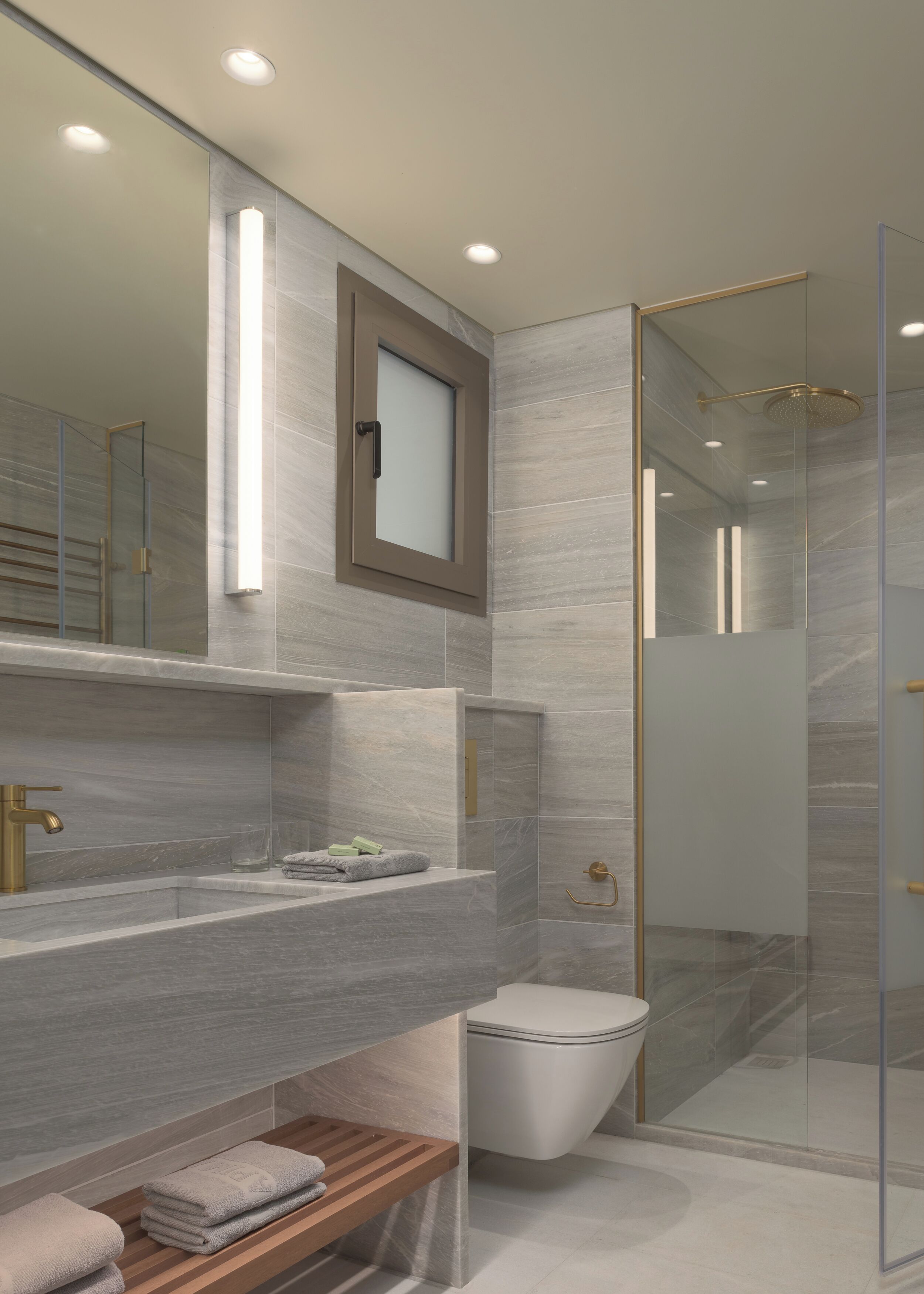 A modern bathroom with a glass shower enclosure, a vanity with a mirror, and a toilet.