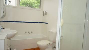 A bathroom with a bathtub, toilet, and sink.