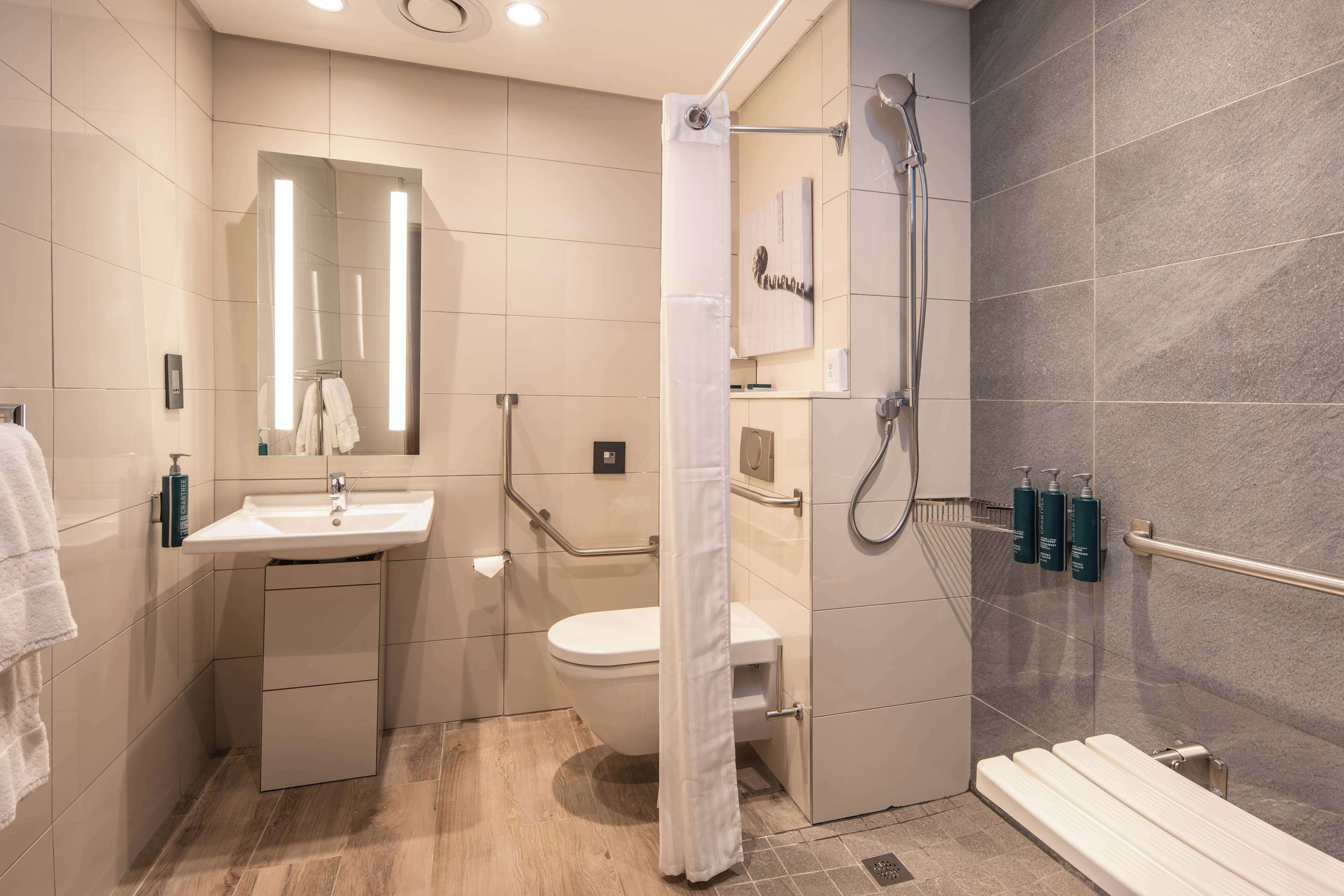 A modern bathroom with a sink, toilet, and shower area.