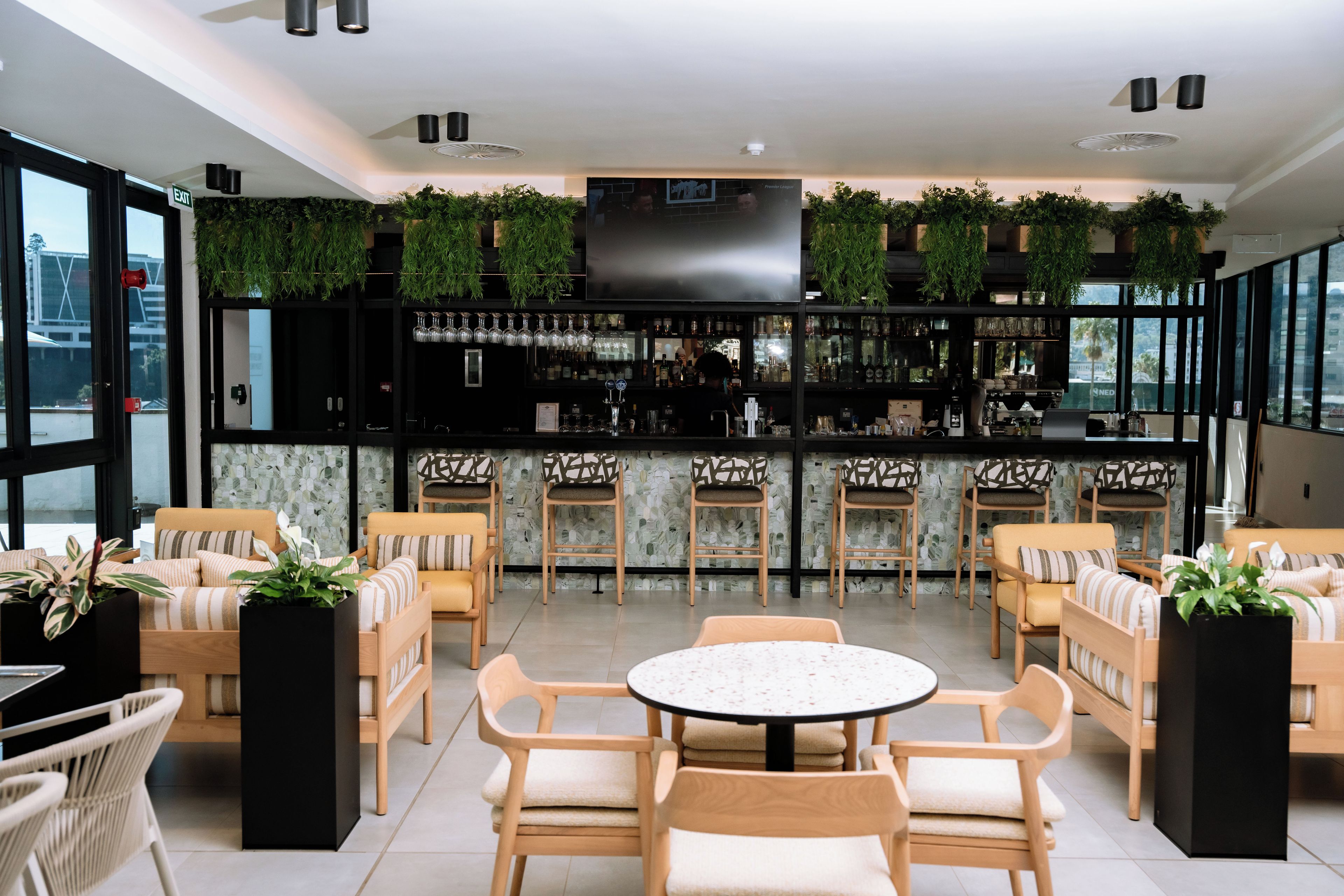 A bar area with seating and a TV screen.
