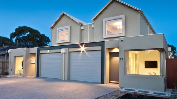 A modern two-story house with a garage, a driveway, and a well-lit entrance. - Amaroo by the beach and Swan Bay (Queenscliffe)