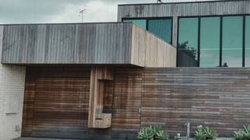 A modern building with a wooden facade, large windows, and a garage door.