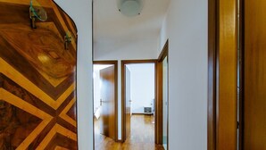 Un passadís amb sòl de fusta i un disseny de paret en forma de punt diagonal.