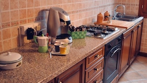 Una cucina con fornelli, lavello e pensili.