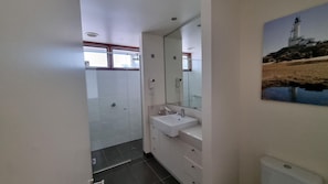 A bathroom with a white sink, mirror, and tiled walls.
