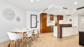 Eine moderne Küche mit Holzausstattung, einer weißen Arbeitsplatte und einem eingebauten Backofen.
