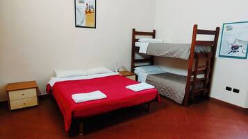 Una habitación con una cama individual, una litera, una mesita de noche y un cartel en la pared.
