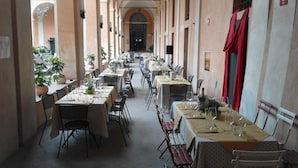 A long corridor with tables and chairs, suggesting a dining area or restaurant. - Student's Hostel della Ghiara (Reggio nell'Emilia)