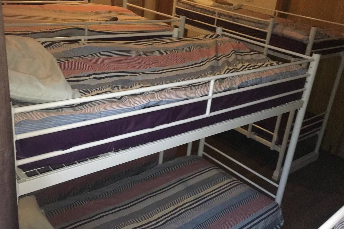 A bunk bed with multiple levels and striped bedding.