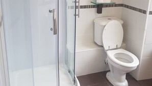 A bathroom with a glass-enclosed shower, a toilet, and a glass shelf with toiletries. - Soprano Hostel (Aberdeen)