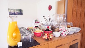 A breakfast buffet with various food items, a pitcher of orange juice, and clear glass containers. - The Old Dairy Farm B&B (Emsworth)
