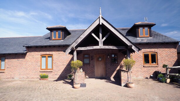 A brick building with a central entrance, two side windows, and a sloped roof. - The Old Dairy Farm B&B (Emsworth)